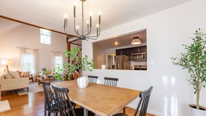 A modern kitchen with built-in appliances, a dining area with a wooden table and black chairs, and a living room with a sofa and a lamp. - Our Peaceful Haven - 6 minutes to Trilith Studios (Fayetteville)