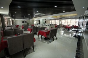 Un restaurante con varias zonas de comedor, incluyendo mesas y cabinas, además de una zona de bar.