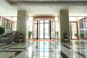 Un hall de hotel con un giratorio, una recepción y una zona de estar.