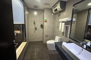 A modern bathroom with a shower, toilet, and a large sink. - Chunguang Hotel (Xiji)