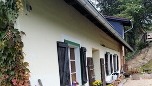 Un bâtiment rustique avec un banc en bois, une échelle et une pile de bois de chauffage.