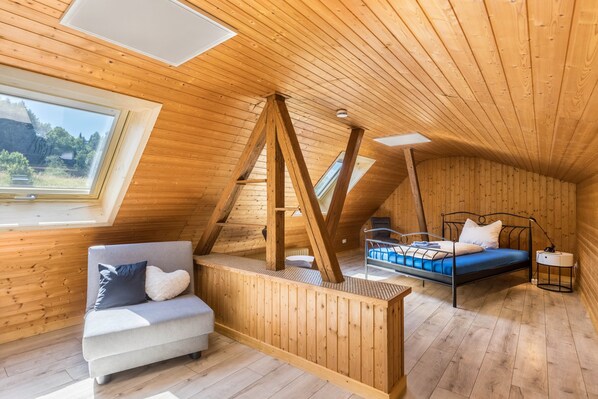 Un intérieur en bois avec un lit, un canapé et une lucarne.