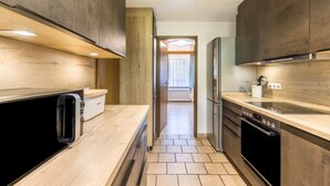 Una cocina moderna con armarios de madera, horno empotrado y encimera.
