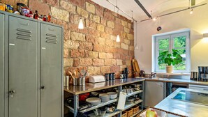Una cocina con pared de ladrillo, armarios metálicos y ventana con vistas.