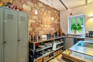 A kitchen with a brick wall, metal cabinets, and a window with a view.