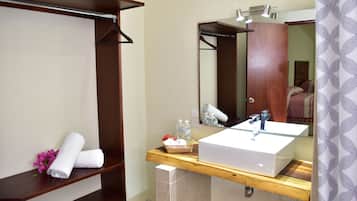A bathroom with a wooden vanity, a large mirror, and a towel rack.