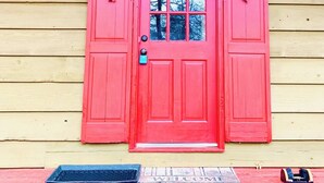 A red wooden door with heart-shaped decorations and a star-shaped light fixture above it.
