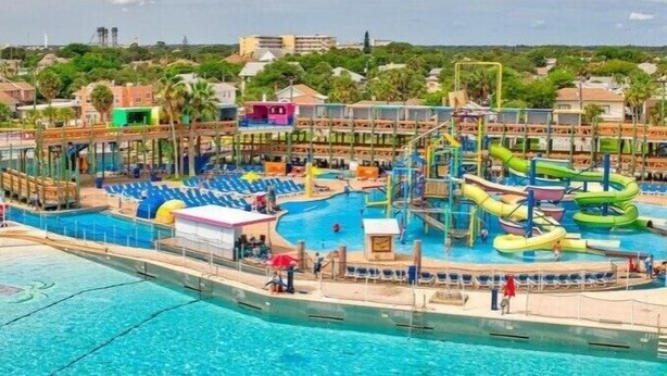 Un parque acuático con múltiples piscinas, toboganes y estructuras de juego.