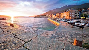 A waterfront promenade with stone paving, boats docked along the shore, and buildings with balconies. - 1BR Seafront Apartment Sanja Karlobag, Karlobag, Croatia (Karlobag)