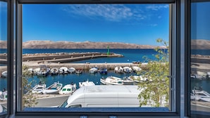 A marina with boats docked, a clear blue sky, and distant mountains. - 1BR Seafront Apartment Sanja Karlobag, Karlobag, Croatia (Karlobag)