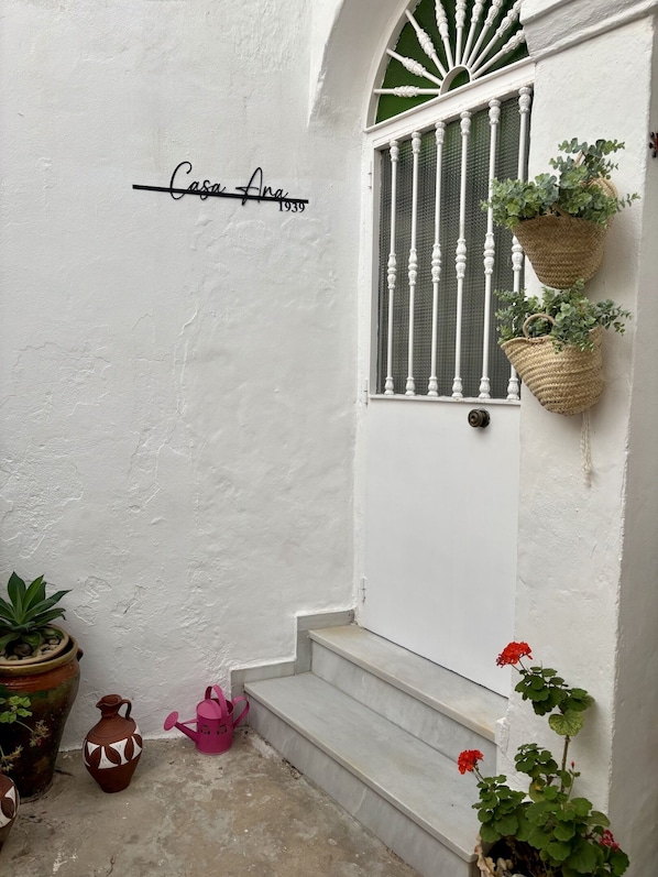 A white door with a window, a sign reading "Casa Ana 1939", and potted plants. - Casa Ana in Vejerde la Frontera (Vejer de la Frontera)