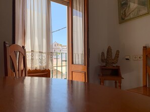 A dining area with a wooden table and chairs, a decorative sculpture, and a painting on the wall.