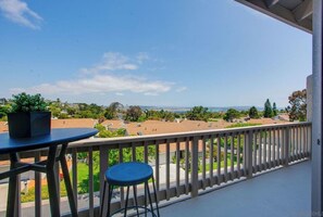 Enjoy a peaceful view of the surrounding neighborhood from this balcony.