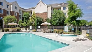 A hotel pool area with a rectangular pool, lounge chairs, and umbrellas. - Better Choice for your Vacation! 2 Posh Units, Free Breakfast, Outdoor Pool! (Vancouver)