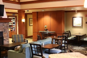 Un hall de hotel con chimenea, zona de estar y kitchenette.