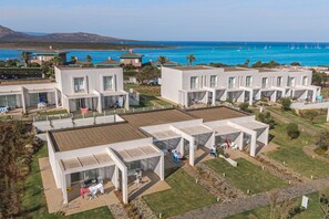 A modern resort with multiple white buildings, outdoor seating areas, and a view of the sea. - Stunning Capo Falcone Apartments 2 Bedrooms sleeps 6 (Stintino)