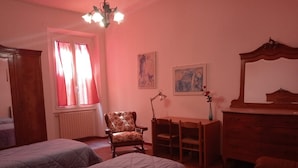 Une chambre avec deux lits, un bureau, une chaise, une commode et un miroir.