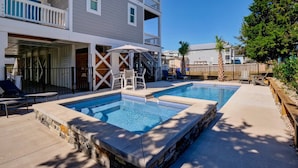 A residential area with two swimming pools, a covered patio, and a multi-story building with balconies. - Blue Oasis - New + Modern w/Ocean Views, Pool + Hot Tub, 2 Min Walk to Beach, Elevator, Dogs OK (Carolina Beach)
