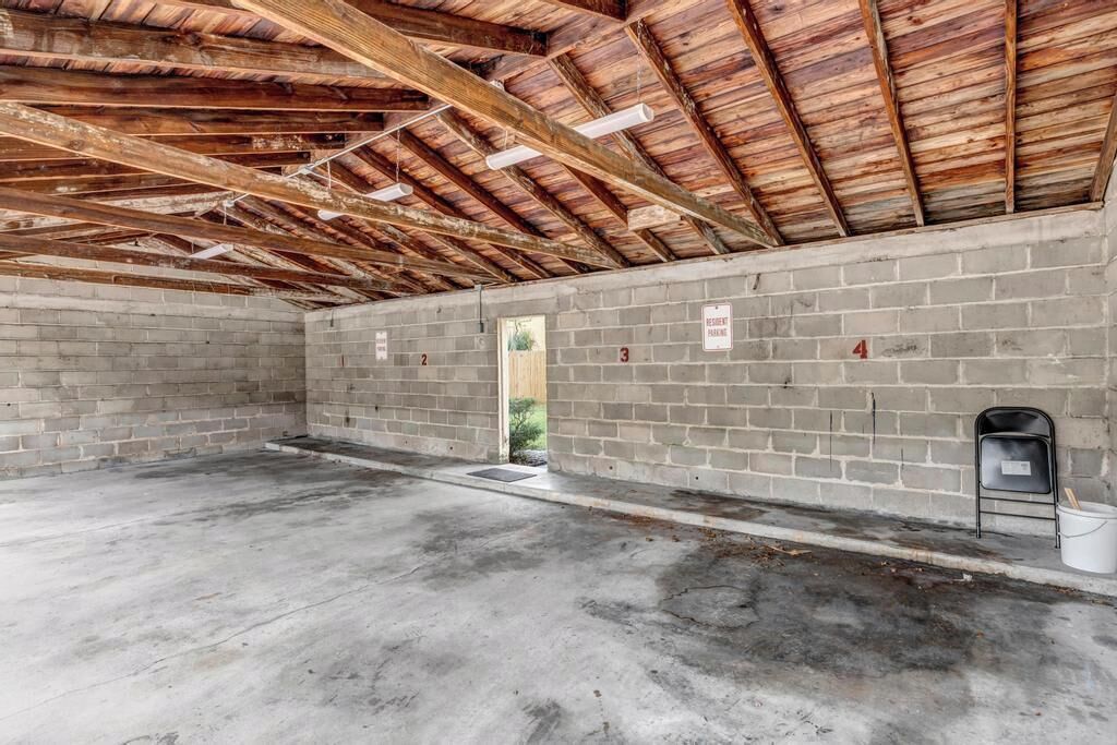 Een ruime, onafgewerkte kamer met zichtbare houten balken en een betonnen vloer, met de cijfers 2, 3 en 4 op de muren.
