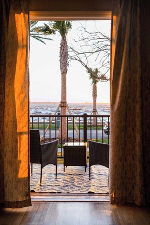 A balcony with wicker furniture and a view of the ocean.
