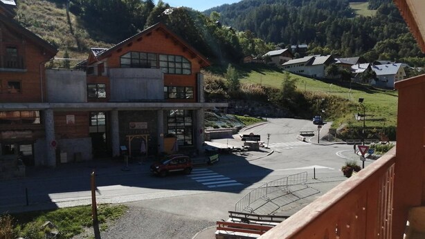 A building with a restaurant sign, a parking lot, and a view of a hilly landscape. - Studio Cabin 4 beds Parking Wifi (VALLOIRE)