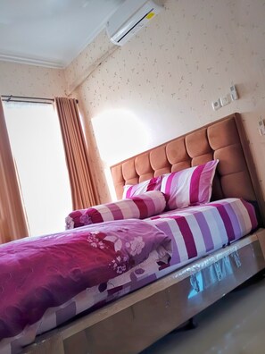 Cozy retreat with a single bed featuring a tufted headboard and striped bedding.
