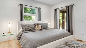 Una camera da letto moderna con un letto, comodini e tende.