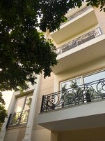 A multi-story building with balconies featuring ornate wrought iron railings.