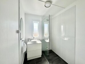 Apartamento estándar (1) | Baño | Ducha, artículos de higiene personal de diseño y secador de pelo