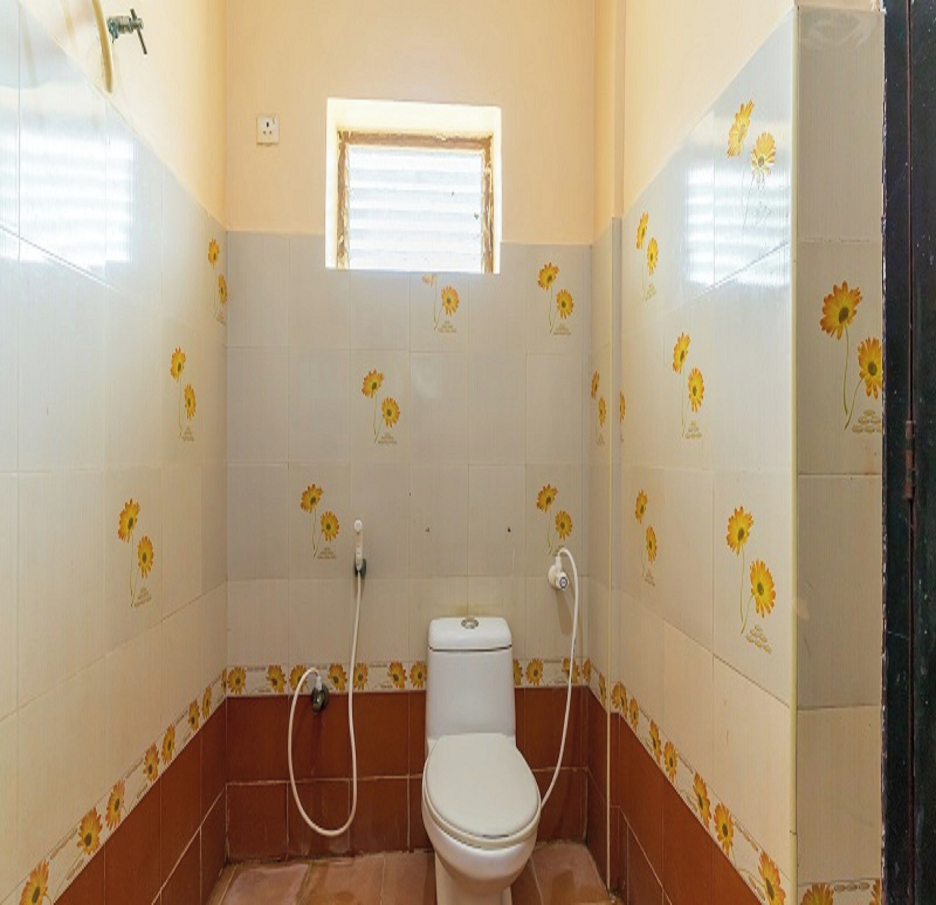 Ein kleines Badezimmer mit Toilette, Fenster und Dusche.