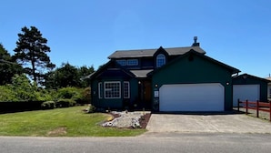 A two-story house with a garage, a driveway, and a well-maintained lawn. - Bugsy's By the Beach ~ Hot Tub, Hammock Station & A/C (Long Beach)