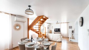 Un espace de vie moderne comprenant un coin repas, un escalier et un téléviseur.