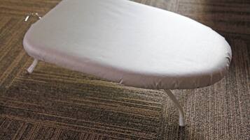 Una taula d'estricció blanca amb potes metàl·liques sobre un moqueta amb relleu.