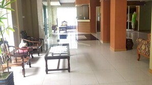 A spacious living area with a high ceiling, a central coffee table, and a seating arrangement including a sofa and chairs. - Hotel O Rumah Massagena Syariah Near Gedung Olahraga Enrekang (Makassar)