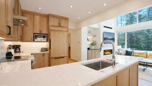 A modern kitchen with wooden cabinets, a stainless steel sink, and a built-in fireplace.