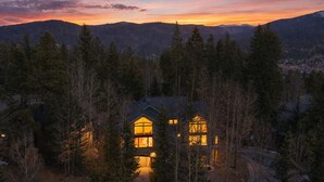 A house surrounded by trees with a view of mountains in the background.