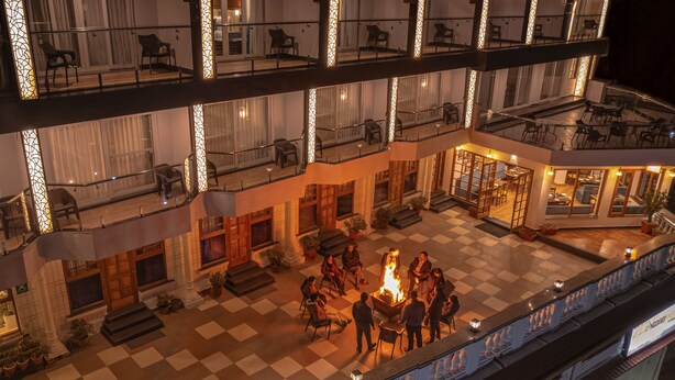 A multi-level outdoor terrace with a checkered floor, seating areas, and a central fire feature. - Zone Connect by The Park Mussoorie (Dehradun)