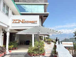 Entrada de un hotel con un cartel que dice "ZONE CONNECT BY THE PARK".