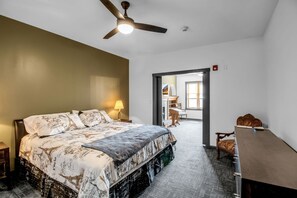A bedroom with a bed, a desk, and a chair. - Webber Hotel (Lyndonville)