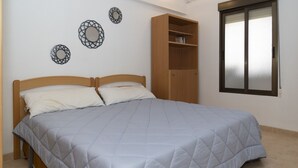 A bedroom with a bed, a wardrobe, and a window.