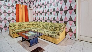 Una sala de estar con una pared decorada, un sofá y una mesa de centro.