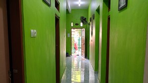Un pasillo con paredes verdes y un piso de baldosas brillantes.