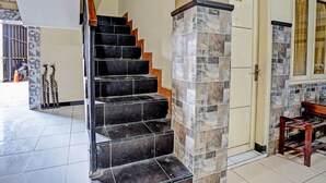 Eine Treppe mit schwarzen und braunen Stufen führt zu einer Tür, die mit der Nummer 008 gekennzeichnet ist.