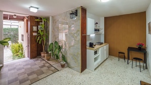 A compact kitchen with a marble backsplash, wooden accents, and a small dining area with a table and chairs. - Breezot Yam (Nahariya)