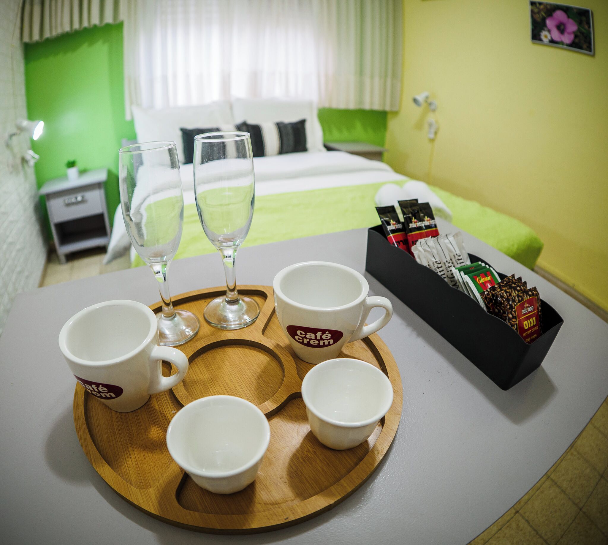 Bandeja de desayuno con tazas de café y una caja de café instantáneo sobre una mesa en una habitación de hotel.