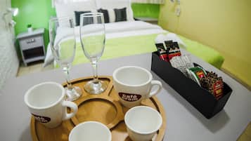 Un plateau de petit-déjeuner avec des tasses de café et une boîte de café instantané, posé sur une table dans une chambre d’hôtel.