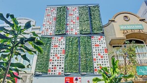 A building with vertical gardens on the facade, a sign reading "JASA BOGA RAYA", and a storefront with a red sign. - Capital O 92765 J&b Smart Sentul (Citaringgul)