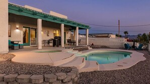 A pool area with a covered patio, outdoor seating, and a view of the mountains. - Havasu Paso - Pool, Spa, Games, Mountain Views (Lake Havasu City)