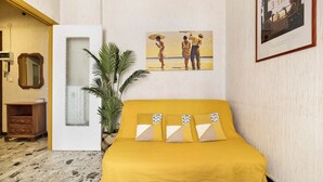 A room with a yellow bed, a framed painting, a potted plant, and a wooden cabinet. - Holiday Apartment 'Riva Mare 2' Near the Beach with Sea View and Parking Space (Vado Ligure)