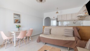 Una sala moderna con sofá, mesa de centro y comedor con sillas.